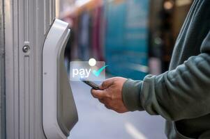 man using smartphone tap to pay at pay station for  ticket or transportation services, buy and scan to pay photo