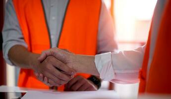 Engineers or foreman shaking hands at construction site, Construction worker in protective uniform shaking hands at construction site photo
