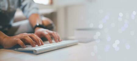 man typing on wireless keyboard, sitting on couch at home, working form home concept, work online and communication, sending reading email, copy space photo