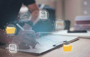 Businessman writing on notebook in office  on table with virtual document data charts. Concept of finance planing and analyzes business and growth. working from home concept. photo