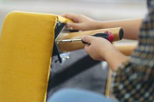 Asian Woman self repairs furniture renovation using equipment to diy repairing furniture sitting on the floor at home photo