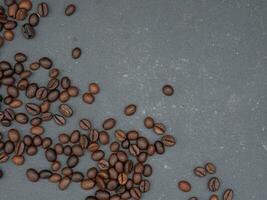 top view of scattered coffee beans on black table with copy space for background photo