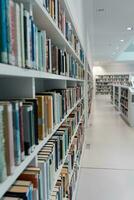 un grande número de estantería con libros. blanco estantería en el biblioteca, en cuales allí son muchos libros. foto