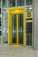 Yellow elevator car. Glass elevator cabin in a public building. Loft style. Sector B photo