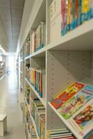 White bookshelves in the library, on which there are many books. photo