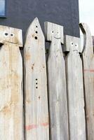 Beautiful fence with figures of people. Handmade work. A product made of wood. Beautiful wooden fence. photo