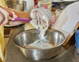 cocinero agrega crema fraiche a un cuenco de tarta ingredientes foto