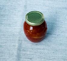 Traditional Hungarian homemade lecho in glass jars. Preserved tomatoes and peppers with spices. photo