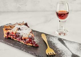 elegante delicadeza, clásico linzer pastel con cerezas y vaso de Jerez en mármol foto