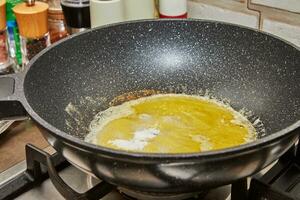 Caramelized syrup in frying pan on gas stove fire photo