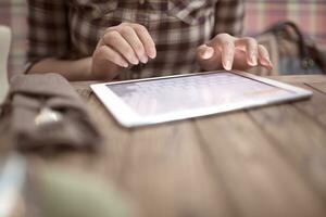 Woman in cafe typing on touch pad photo