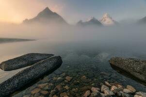 Scenery of mount Assiniboine in foggy on Magog lake at the morning photo