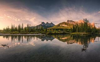 panorama de Tres hermanas montaña reflexión en estanque a amanecer en otoño a banff nacional parque foto