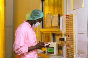 Employee male writing time card to start working at processing plant photo