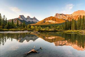 Scenery of Three sisters mountain reflection on pond at sunrise in autumn at Banff national park photo