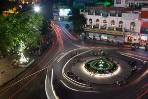 noche tráfico en el cuadrado con movimiento caminos. Hanoi, Vietnam foto