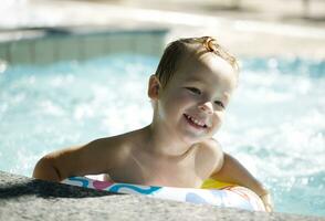 Kid learns to swim using a plastic water ring photo