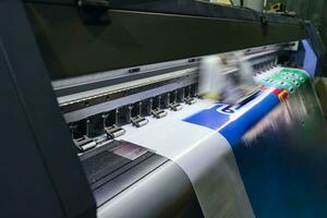 Large format inkjet printer working on vinyl paper in workplace photo