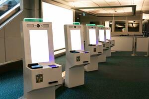 Self service card dispenser with passport scanner touch screen in immigration zone at the airport photo