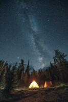 Camping in pine forest with milky way and shooting star at Assiniboine provincial park photo