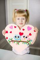 A blogger girl makes a felt craft for Valentine's Day in the shape of a heart. The concept of children's creativity and handmade. photo