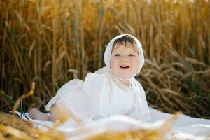 A child boy in white clothes is relaxing in the fresh air in a field photo