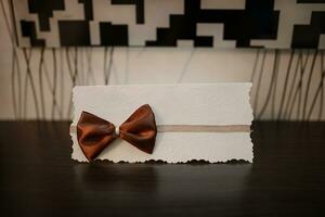 Wedding invitation with a brown satin bow photo