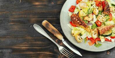 Octopus salad with raw vegetables. photo