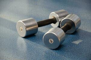 dumbbell, dumbbell in the gym on a blue background. gym for fitness. exercise equipment in the gym. photo