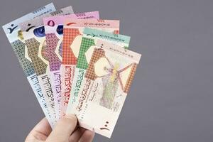 Omani money in the hand on a gray background photo