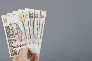 Surinamese money in the hand on a gray background photo