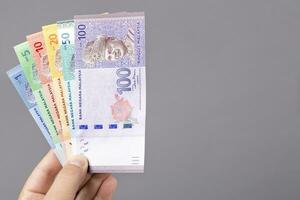 Malaysian ringgit  in the hand on a gray background photo