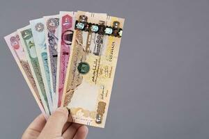 United Arab Emirates money in the hand on a gray background photo