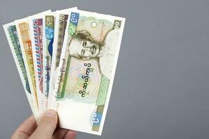 Old Myanmar money in the hand on a gray background photo