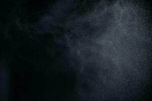 agua rociar polvo en oscuro antecedentes. pulverización niebla efecto aislado en negro antecedentes. foto