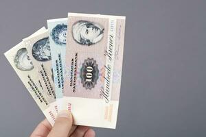 Old Danish money in the hand on a gray background photo