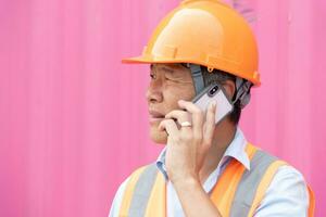 mantenimiento trabajador trabajando con carga contenedores ingeniero en la seguridad casco, reflexivo chaleco, participación walkie película sonora con envase exportar y importar negocio y logística antecedentes. foto