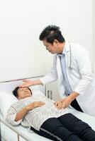 male doctor discussing over medical record with senior woman in hospital. photo