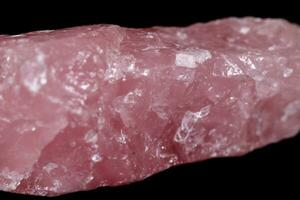 Macro mineral stone Pink quartz on black background photo