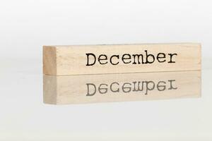 a wooden cube with an inscription December on a white background photo