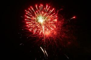 a large red and green fireworks is lit up in the night sky photo