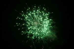 a green firework is lit up in the dark sky photo