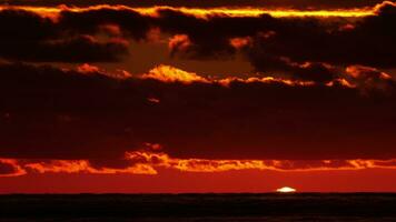 Scenic view of sun setting beyond the horizon over the sea. video