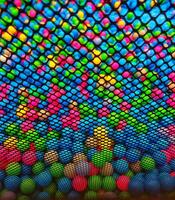 Colored plastic balls are scattered. Lots of multi-Color fun balloons.Many colorful plastic balls in a kids' ballpit at a playground. Close up pattern photo