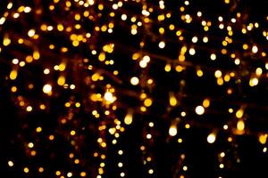 Blurry garland lights on a dark background. Festive Christmas and New Year background. Soft focus photo