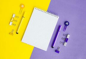 School supplies. Yellow and lilac colors. Empty notebook. Flat lay composition. Space for text. photo