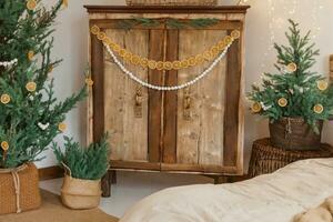 Cozy interior decorated for Christmas in Scandinavian style. Live fir trees decorated with natural ornaments made of dried oranges photo