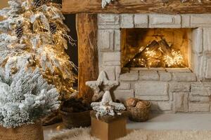 The interior of a room with a fireplace, Christmas trees with artificial snow and garlands, a blanket and a tray with hot drinks. The magical atmosphere of Christmas. photo