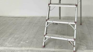 Construction ladder against the background of a white wall in a room in which repairs are underway. video