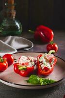 Fresh bell pepper stuffed with cucumber, tomato and greek yogurt on a plate vertical view photo